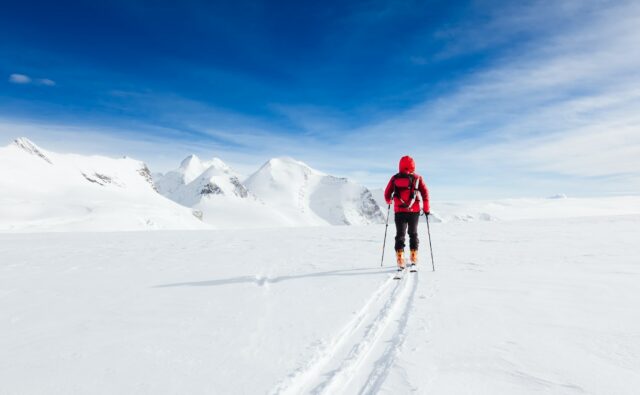 Mountaineer walking on a glacier during a high-altitude winter expedition in the european Alps.